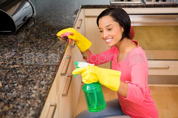 微笑的黑發清潔廚房柜臺